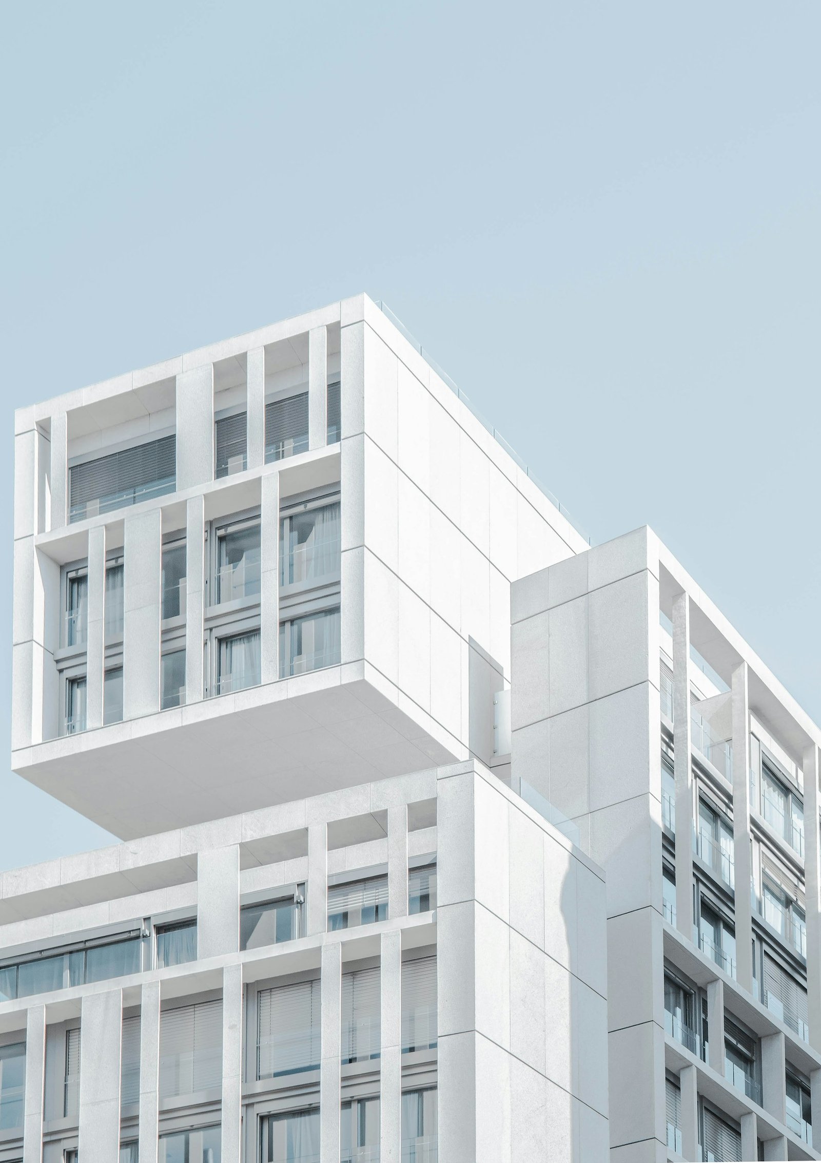 Edificio blanco de volúmenes en voladizo y grandes ventanales.